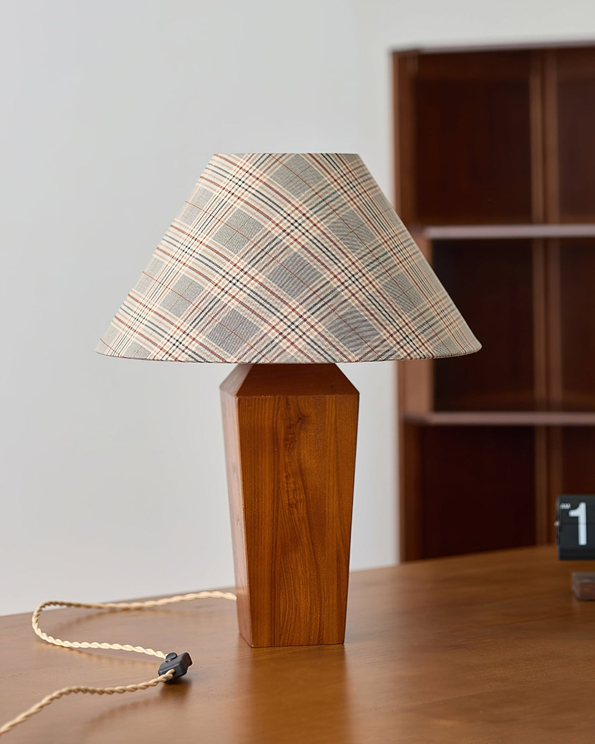 Lámpara de mesa de nogal Tartela – junto a una estantería de madera
