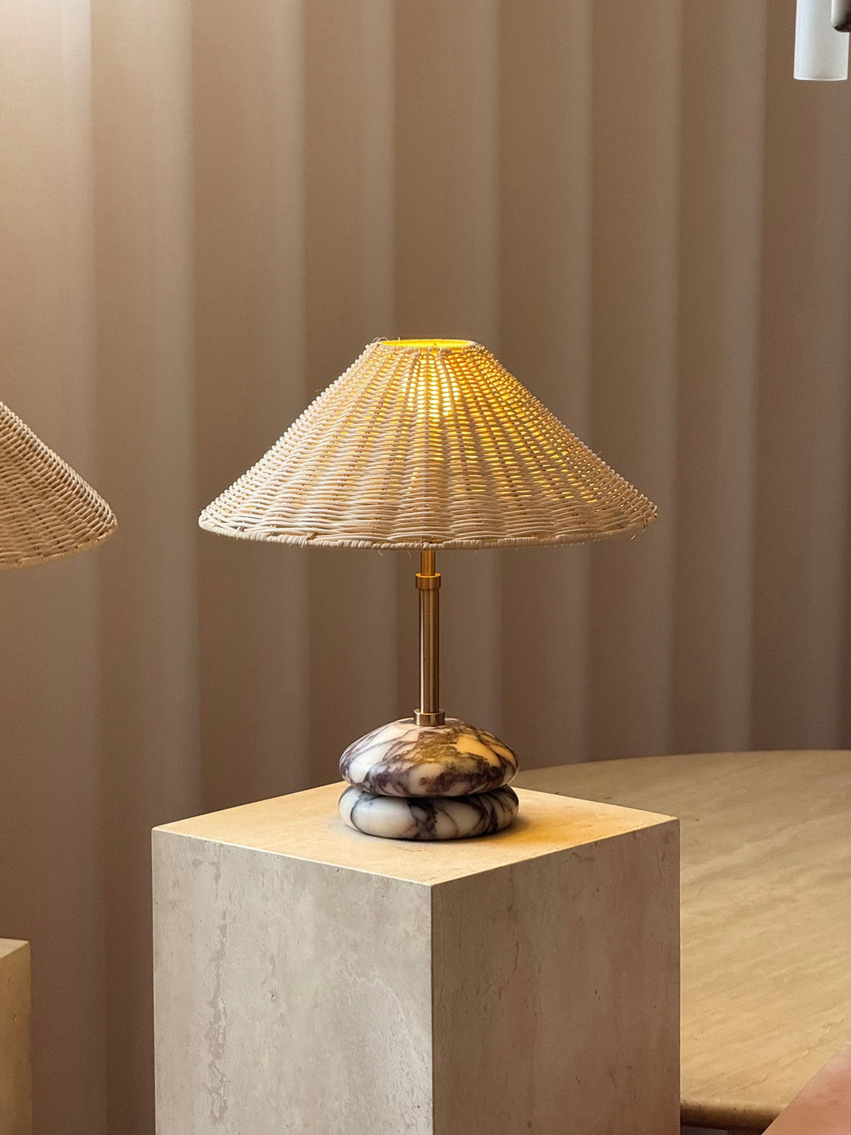 Lámpara de mesa de mármol y ratán Tejuela – encendida con luz cálida