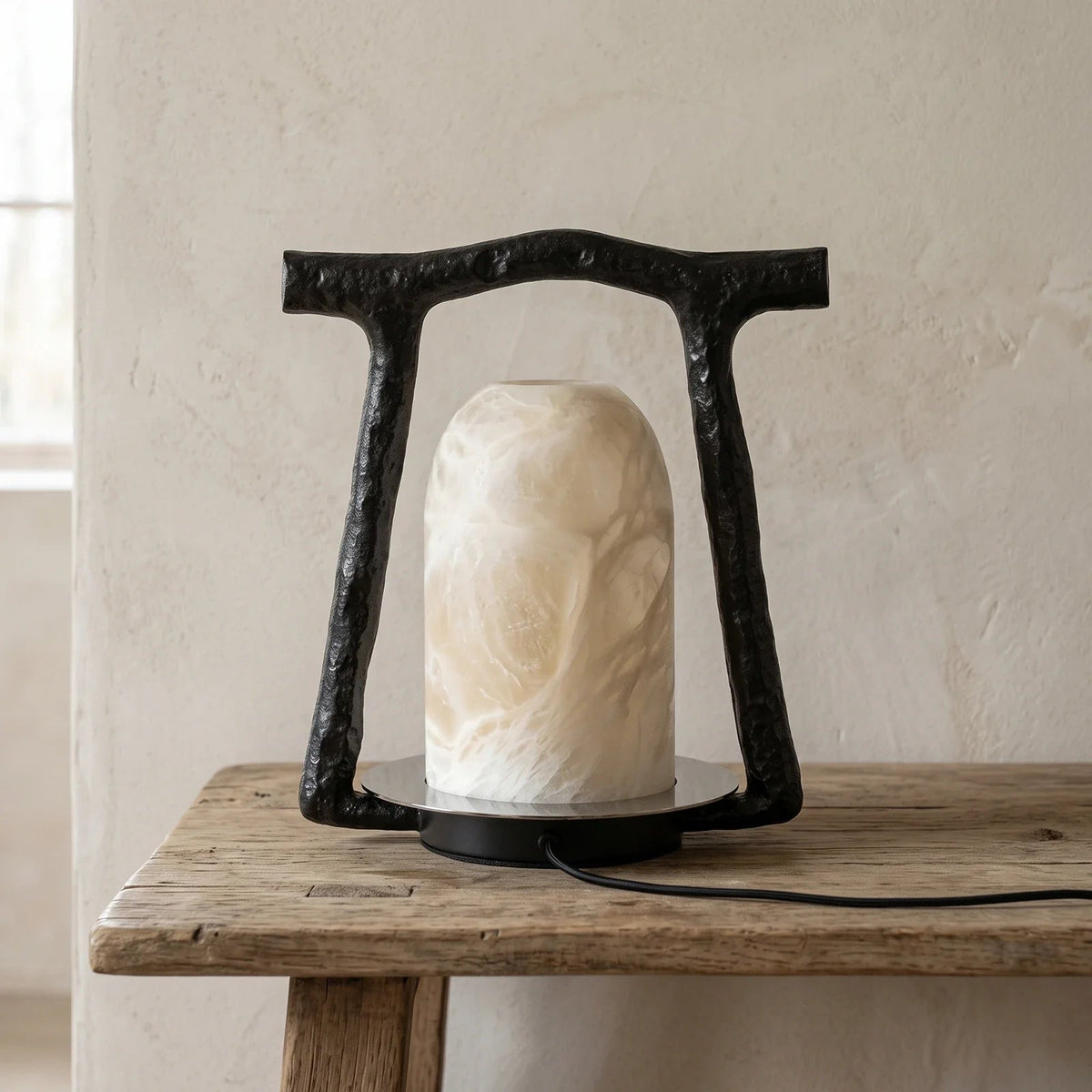 Lámpara de mesa de alabastro Templina – apagada sobre una mesa de madera