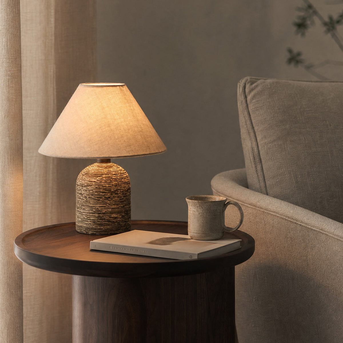 Lámpara de mesita de cerámica Terrona – sobre una mesa auxiliar junto a un sillón