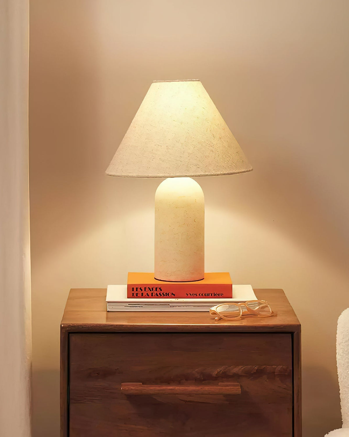 Lámpara de mesa de mármol Tolvara – mármol blanco encendida en una mesita de noche