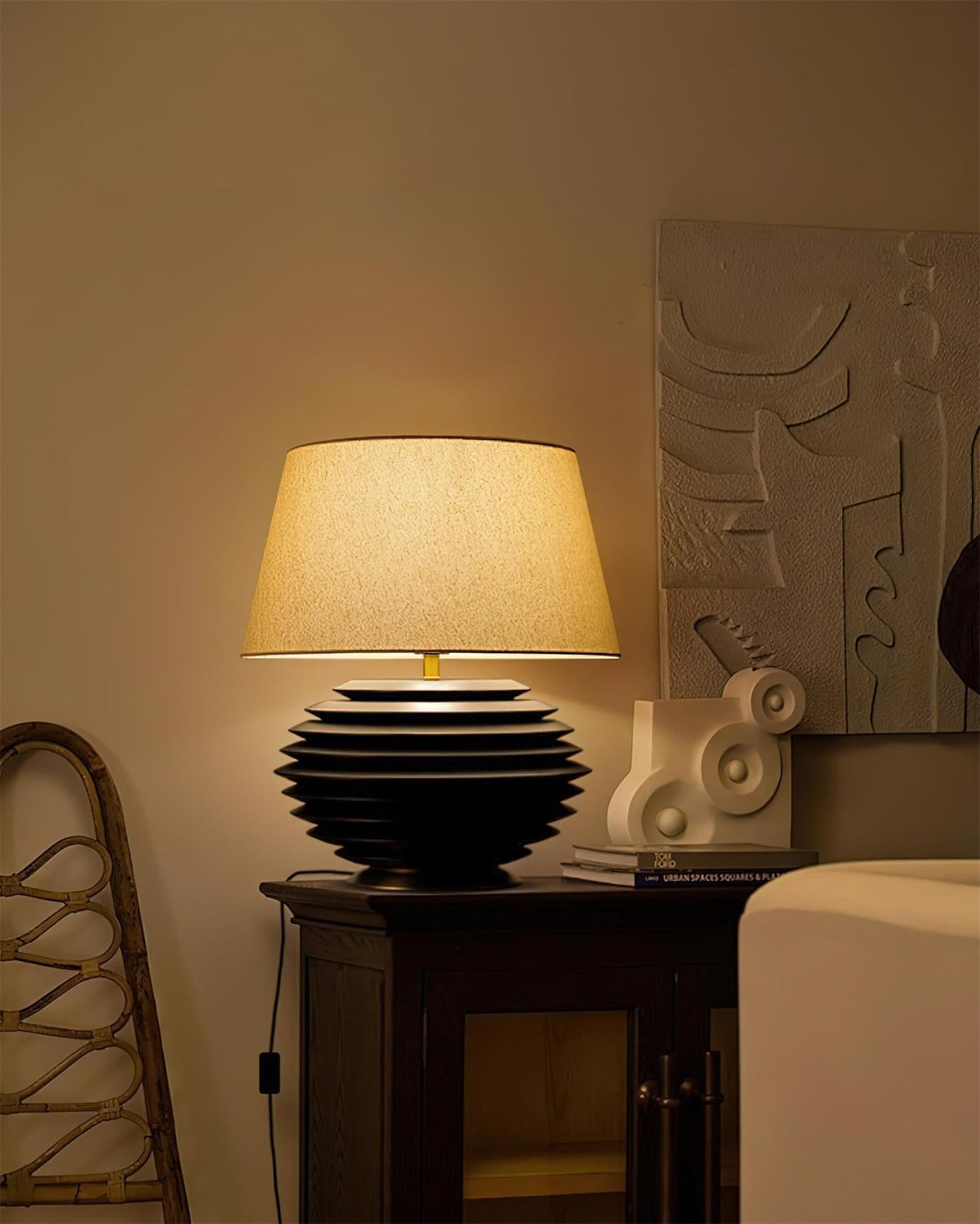 Lámpara de mesa de madera Torneda – negra encendida en un salón