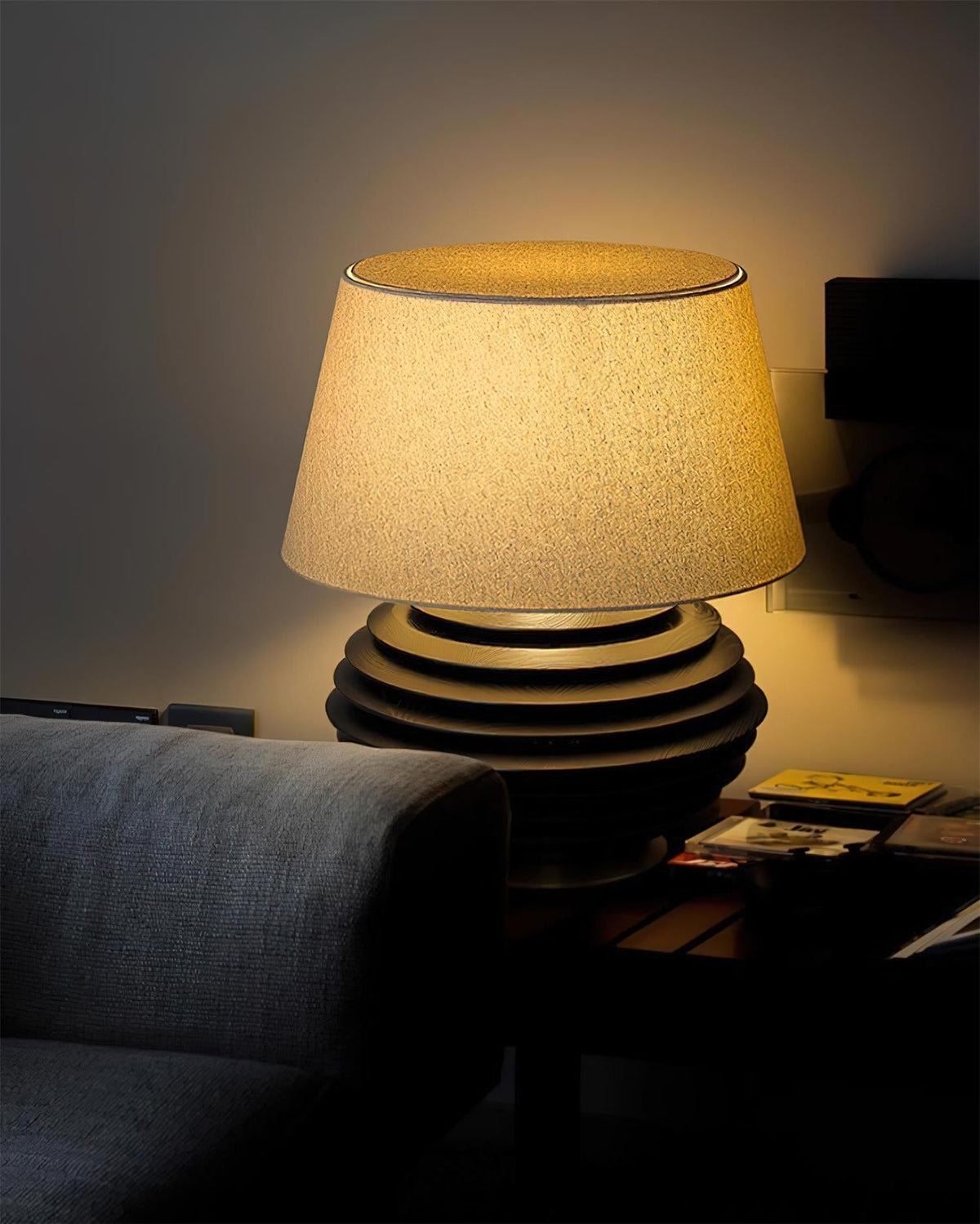 Lámpara de mesa de madera Torneda – encendida junto a un sofá