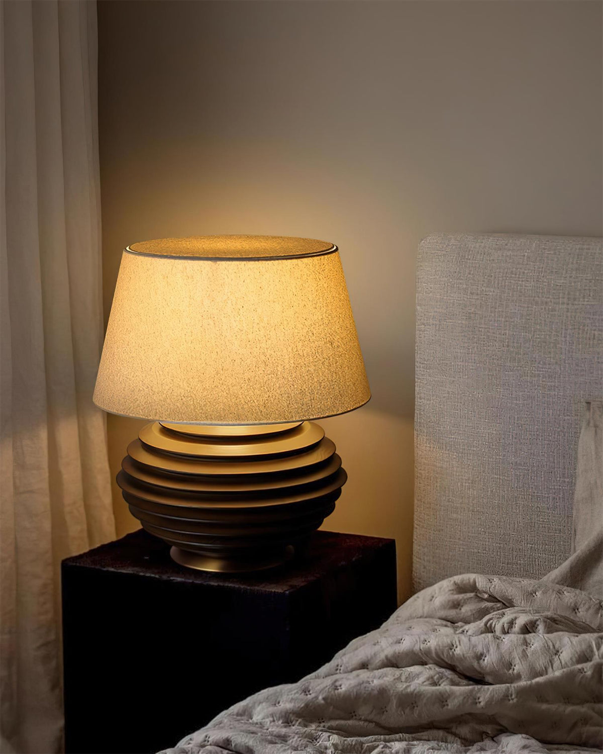 Lámpara de mesa de madera Torneda – encendida en un dormitorio