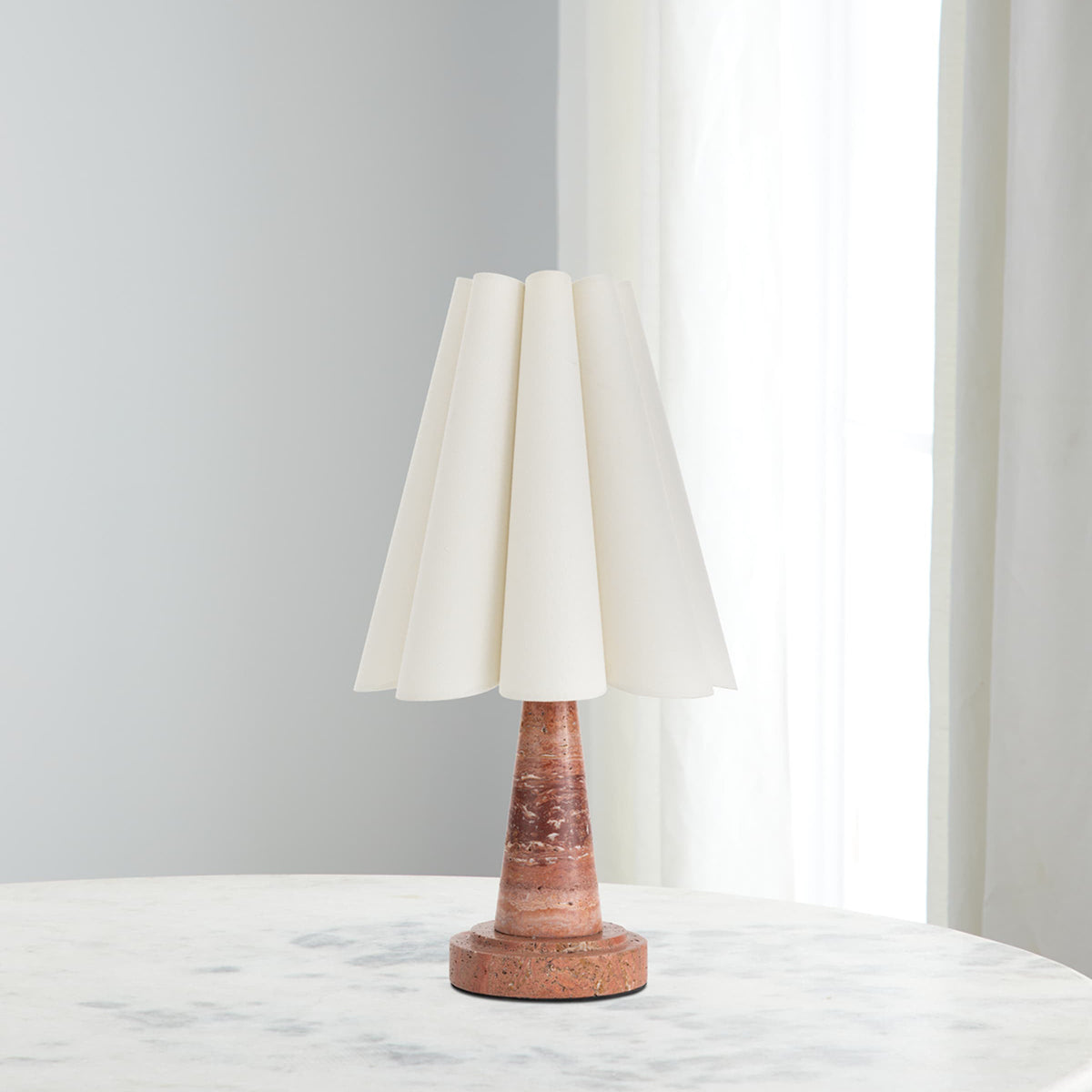 Lámpara de mesa de travertino Tosara – sobre una mesa de mármol junto a la ventana