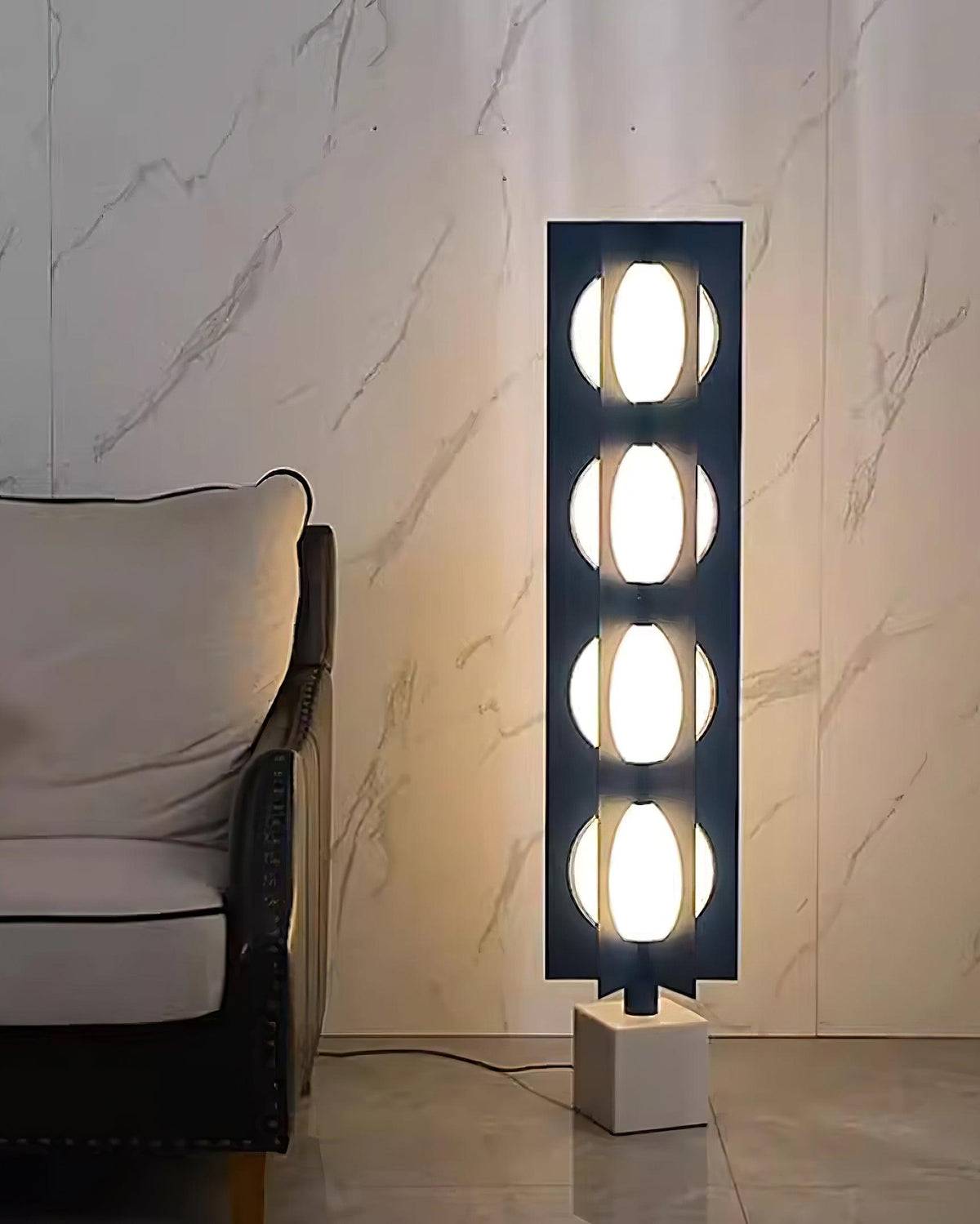 Lámpara de pie LED escultórica azul Toteva – encendida junto a un sillón