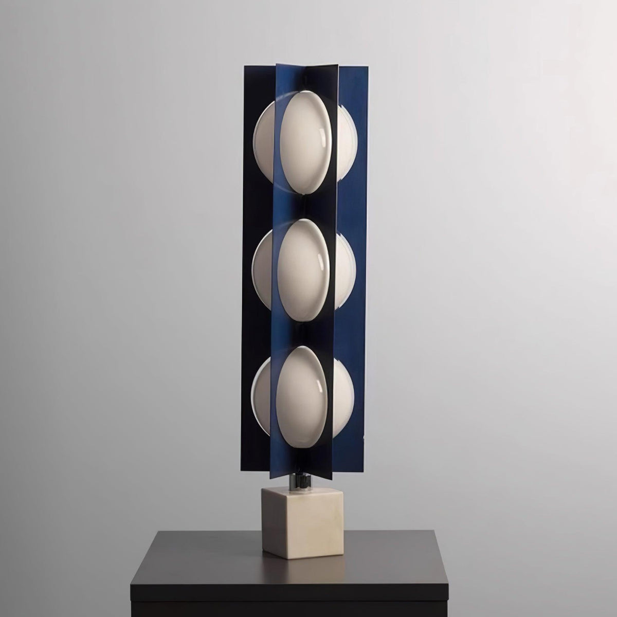 Lámpara de pie LED escultórica azul Toteva – sobre una mesa auxiliar