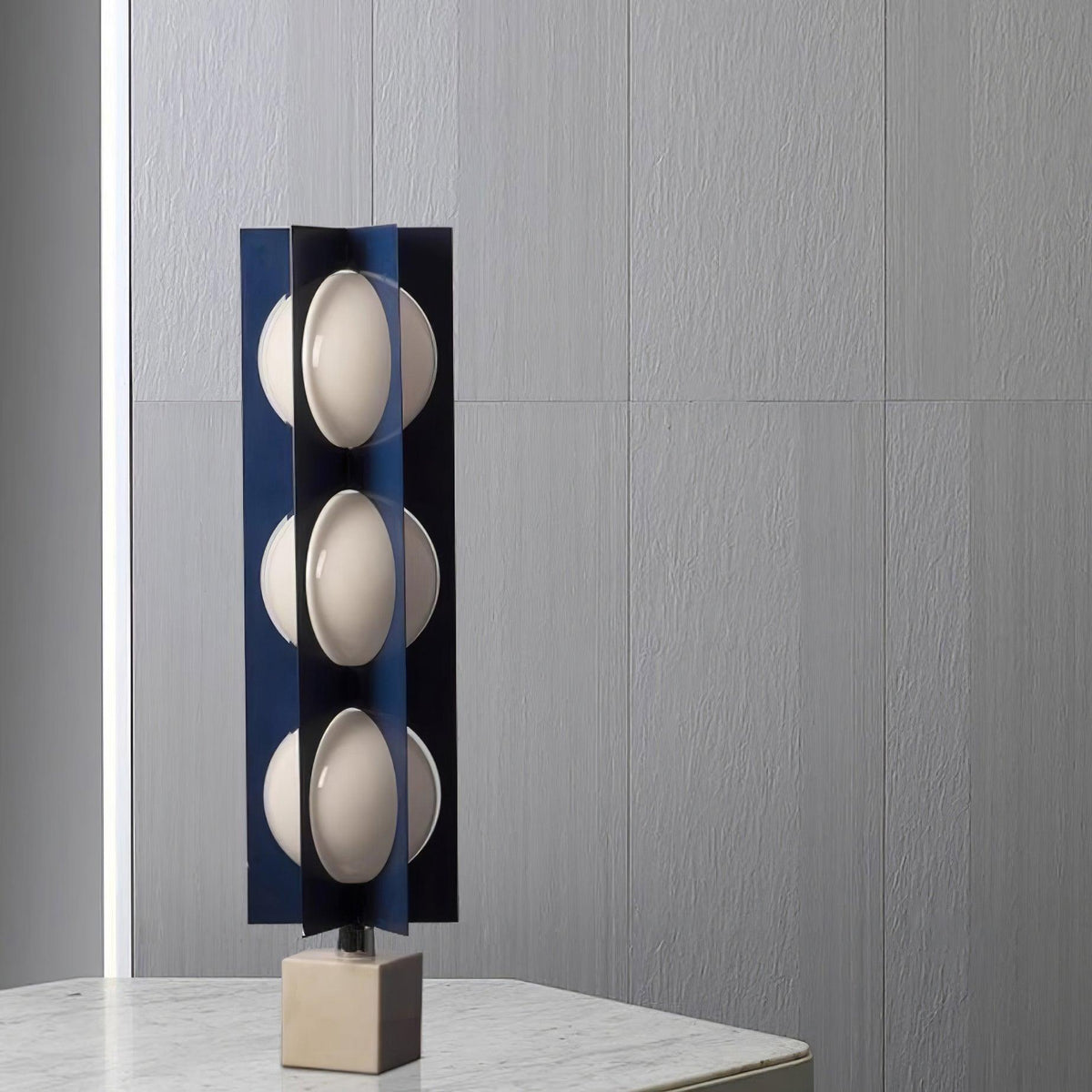 Lámpara de pie LED escultórica azul Toteva – sobre una mesa de mármol