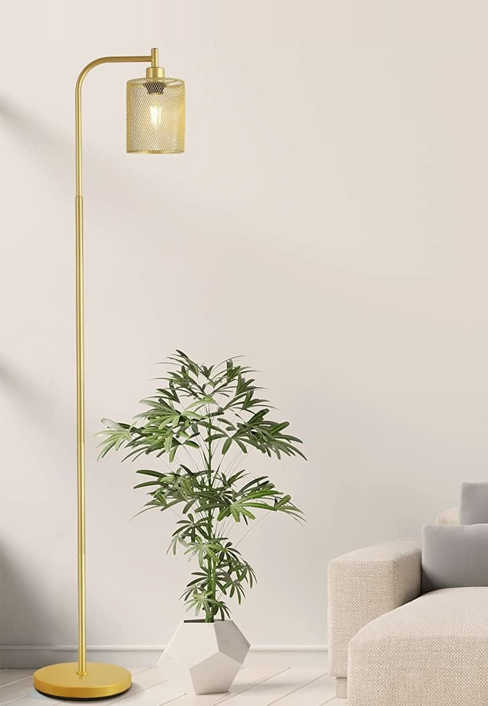 Lámpara de pie industrial dorada Tramela en un salón luminoso