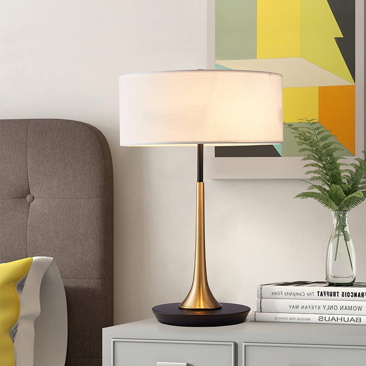Lámpara de mesa dorada Trumela en una mesita de noche – imagen 2