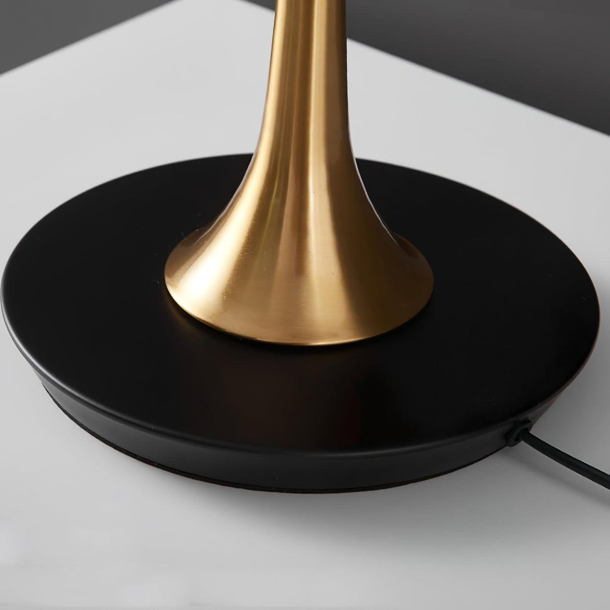 Lámpara de mesa dorada Trumela – detalle del pie dorado y la base negra