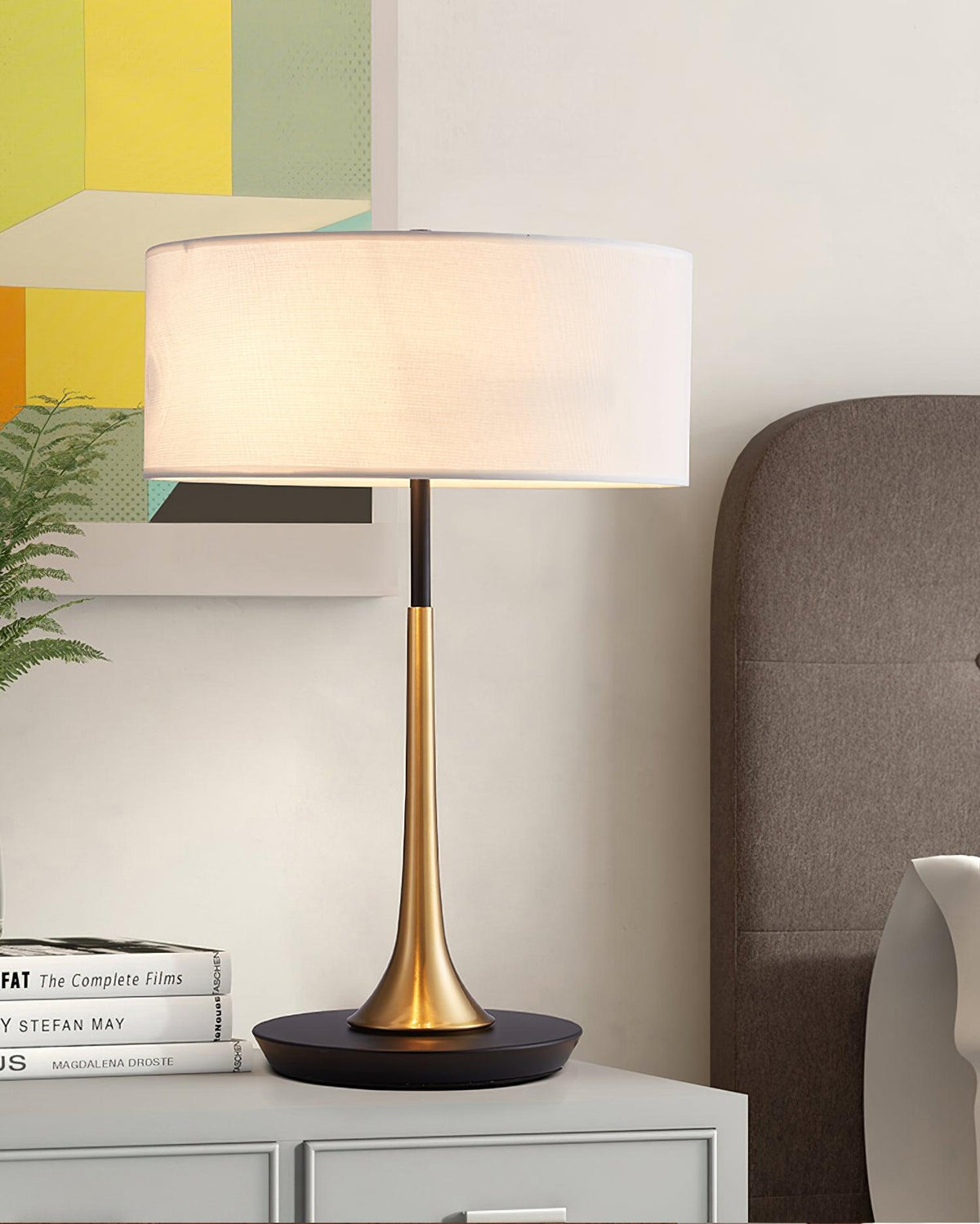 Lámpara de mesa dorada Trumela en una mesita de noche – imagen 9