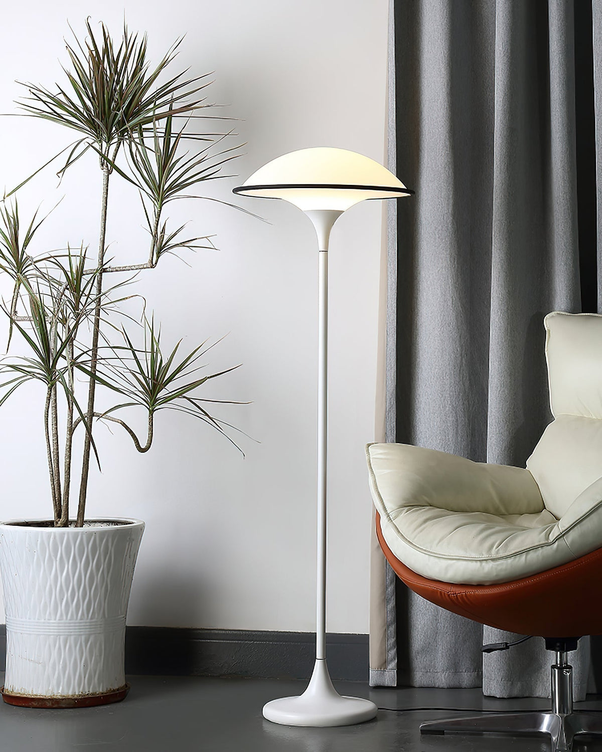Lámpara de pie retro de acrílico Tulivia – junto a un sillón de cuero