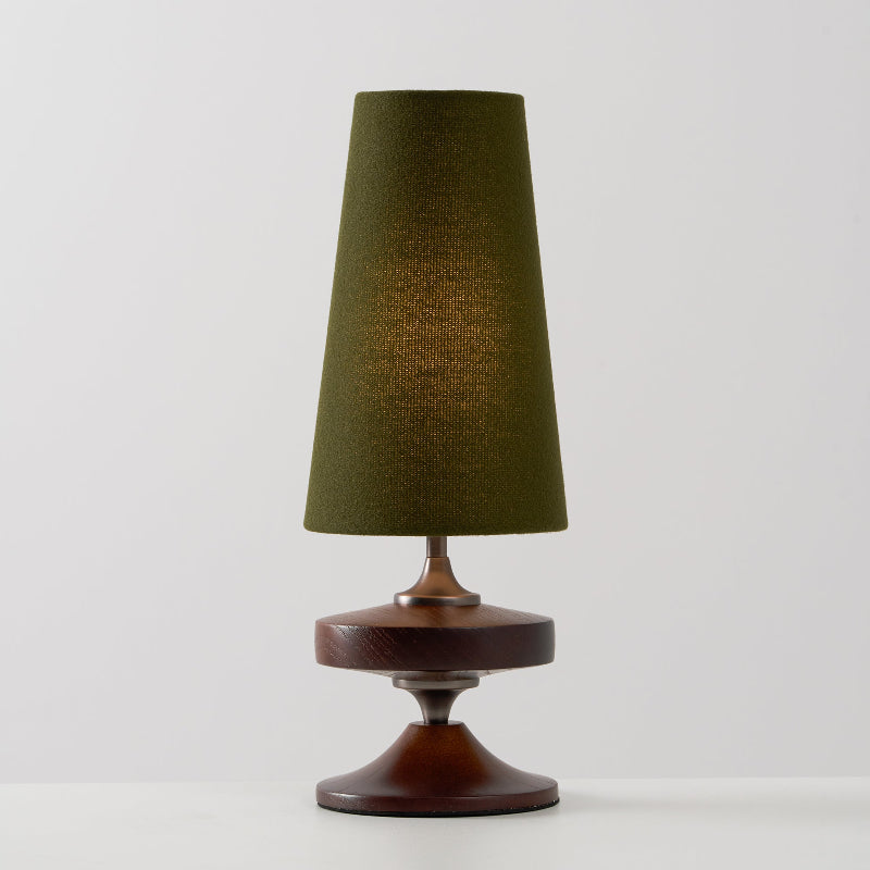 Lámpara de mesa de madera torneada Tulvia – con pantalla verde sobre fondo gris