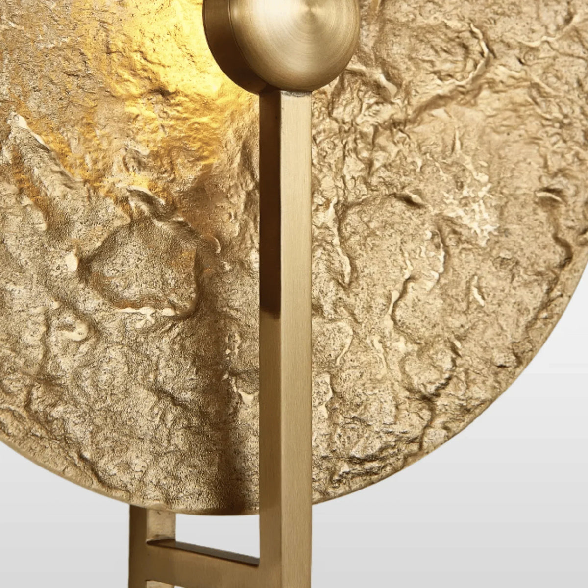 Aplique de pared Yasola con disco martillado dorado – detalle de la textura martillada y la esfera de latón