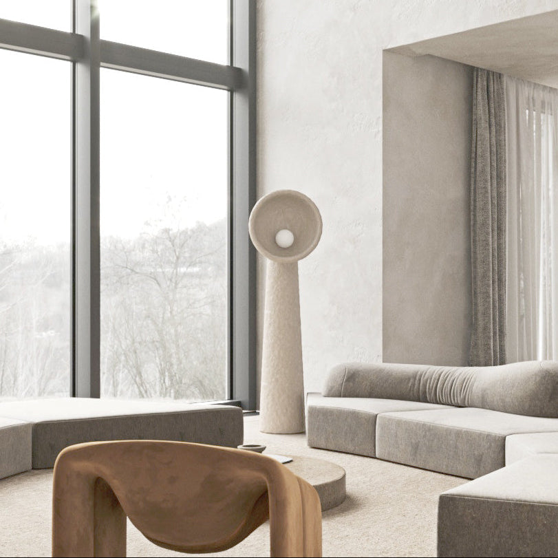 Lámpara de pie escultural Ulmira – junto a un sofá en un salón luminoso
