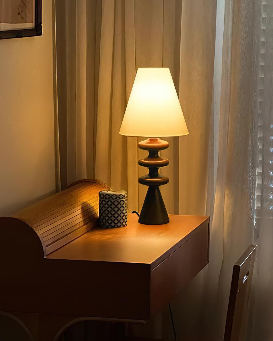 Lámpara de mesa de madera Undora – en negro sobre un escritorio