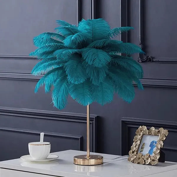 Lámpara de mesa de plumas Vaporela – en verde azulado sobre una mesita