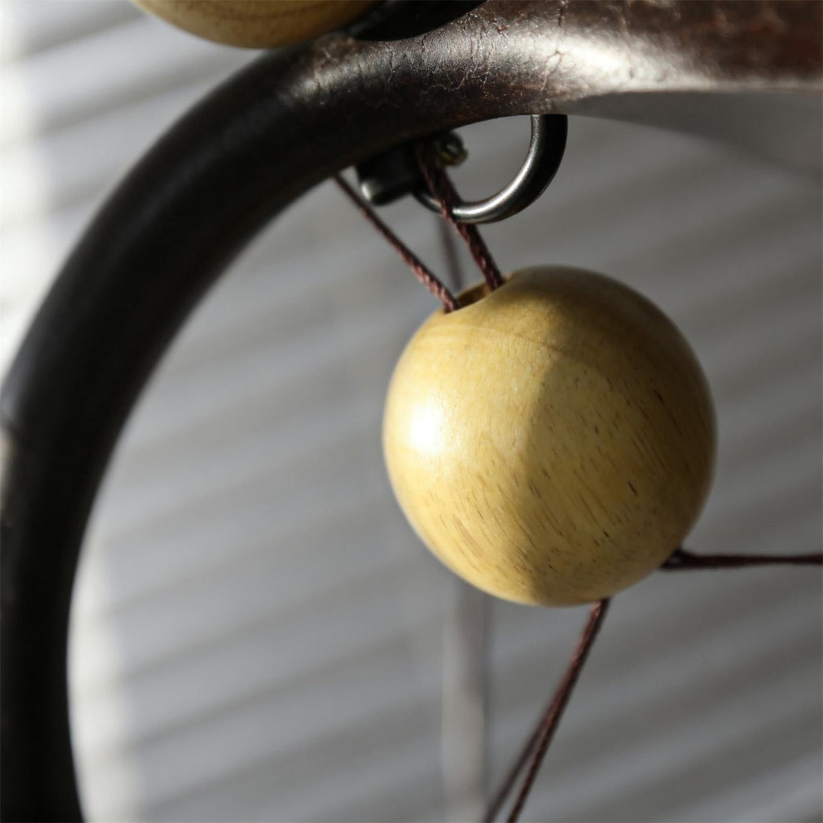 Lámpara de mesa de arco Varcela – detalle de la esfera de madera suspendida