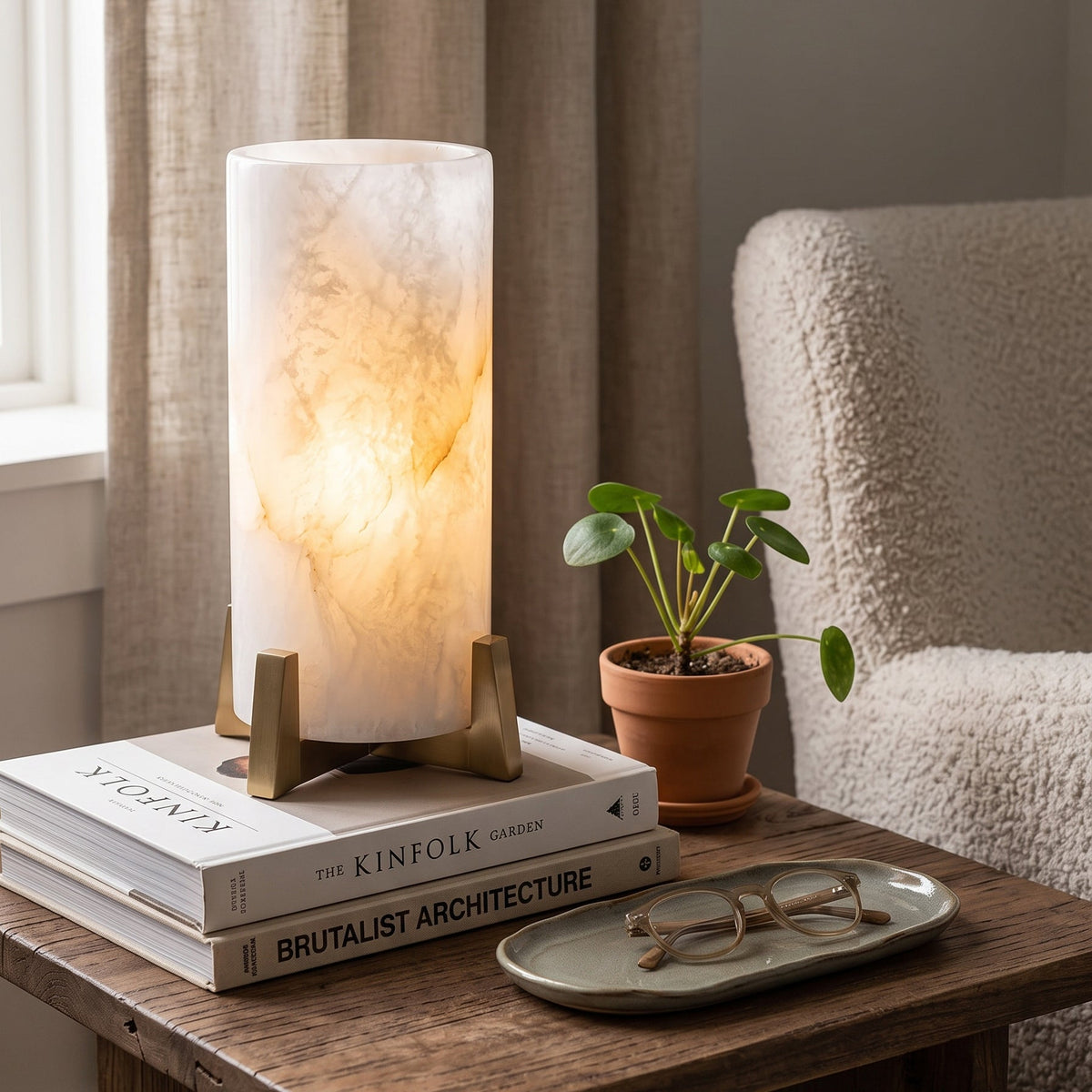 Lámpara de mesa de alabastro Velara – en una mesa auxiliar junto a un sillón