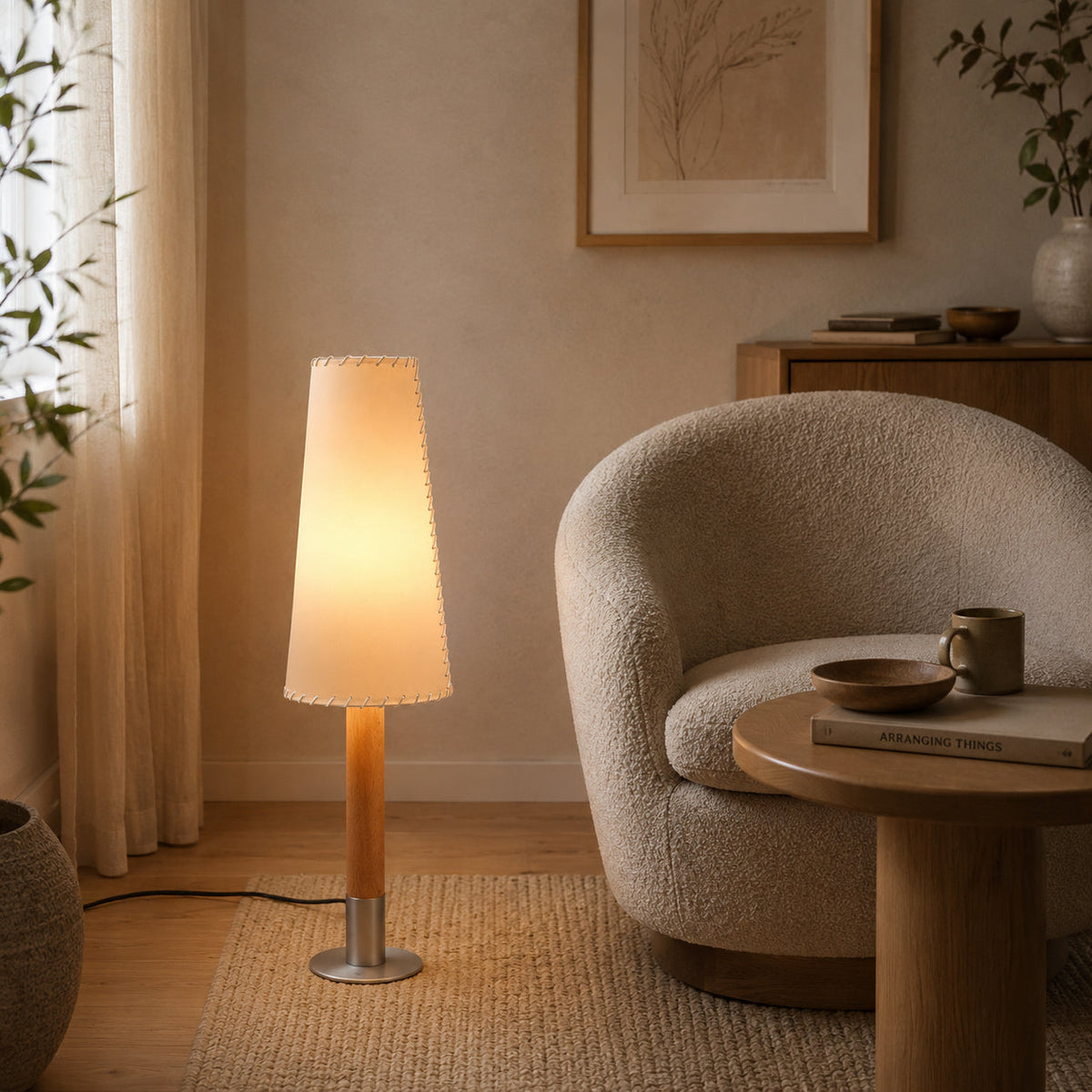 Lámpara de pie baja de pergamino Velarga – junto a un sillón de bouclé