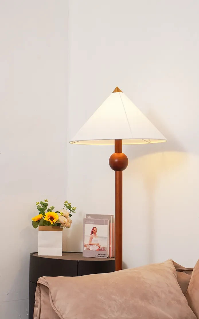 Lámpara de pie de madera Velbora – vista completa junto al sofá