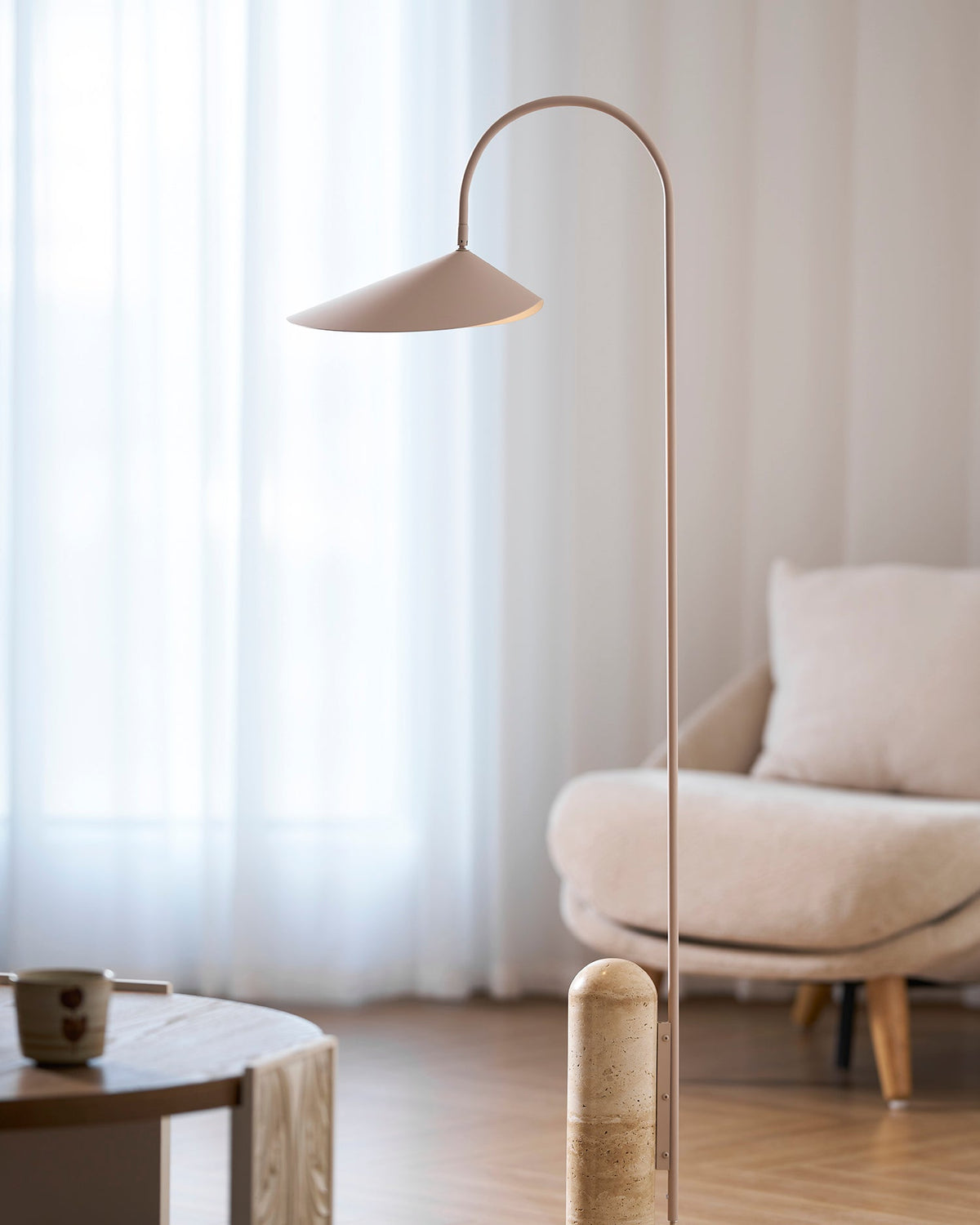 Lámpara de pie minimalista con pantalla de hoja Velhoja – junto a un sillón de lectura