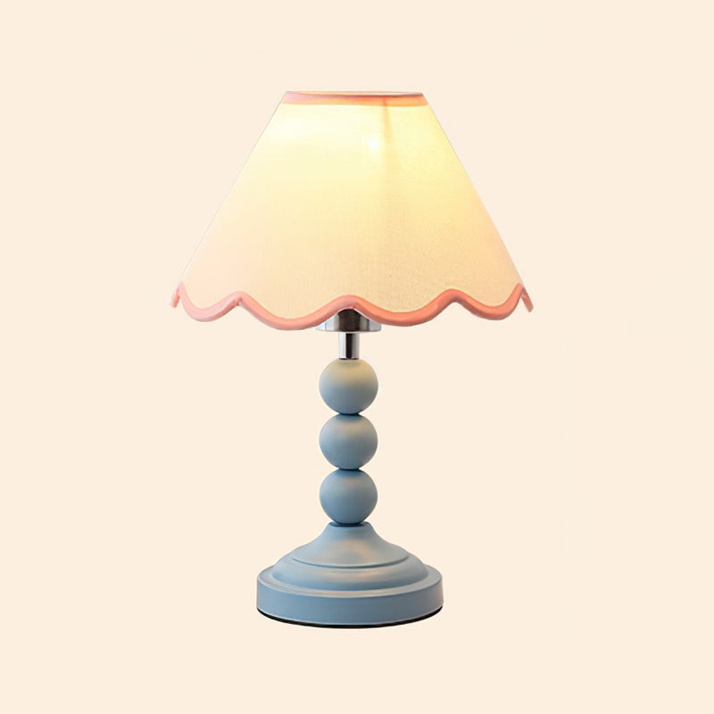 Lámpara de mesa con pantalla ondulada Veloria – encendida sobre fondo claro