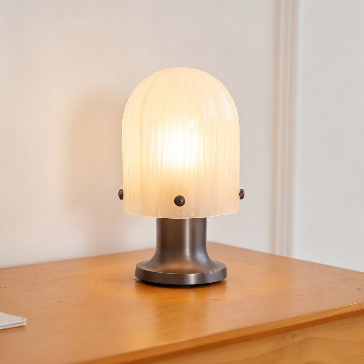 Lámpara de mesa de cristal Velundra – encendida sobre una cómoda de madera