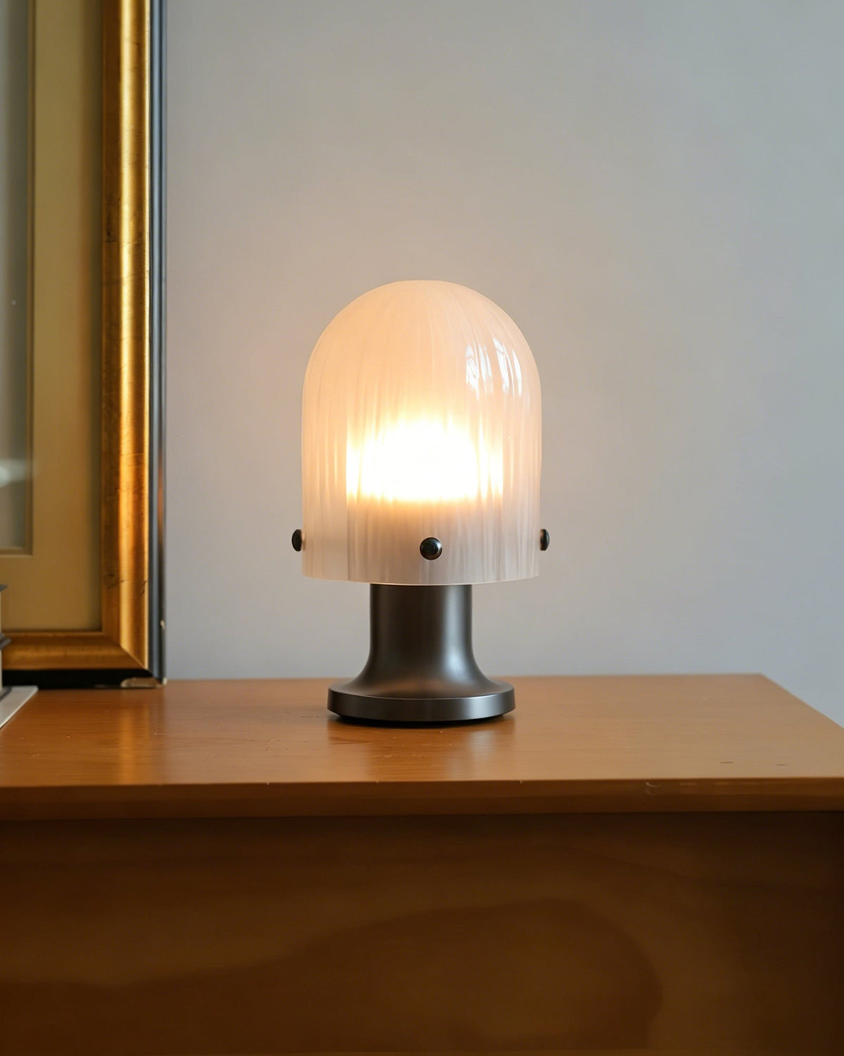 Lámpara de mesa de cristal Velundra – junto a un marco dorado