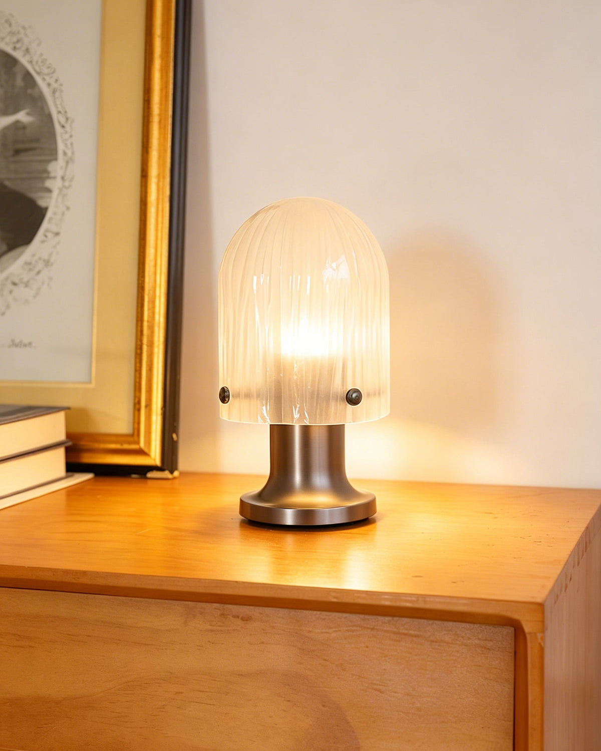 Lámpara de mesa de cristal Velundra – junto a unos libros