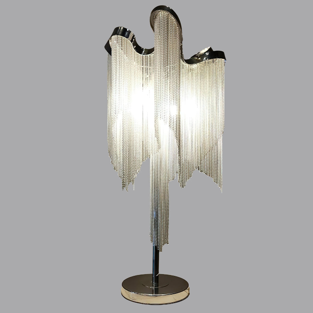 Lámpara de mesa de flecos de cadena Velura – encendida sobre fondo gris