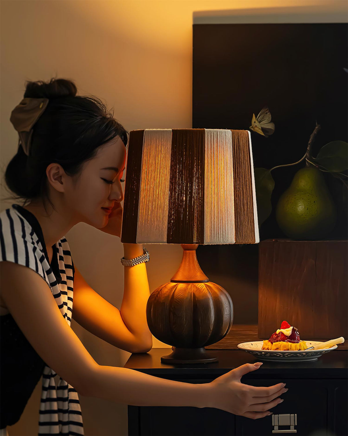 Lámpara de mesa de madera a rayas Vetora – encendida sobre una cómoda