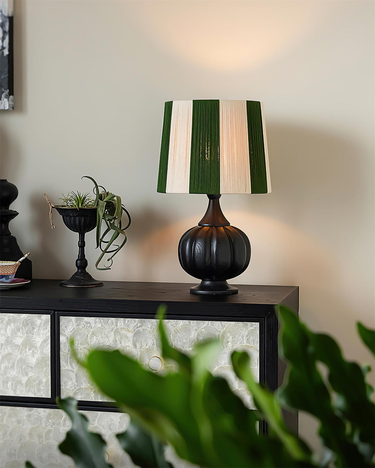 Lámpara de mesa de madera a rayas Vetora – en negro sobre un aparador