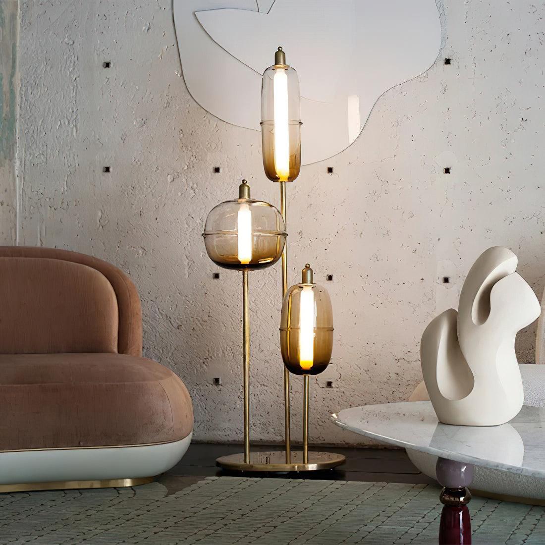 Lámpara de pie LED con cápsulas de vidrio Vidrosa – junto a un sofá rosa y una mesa de mármol
