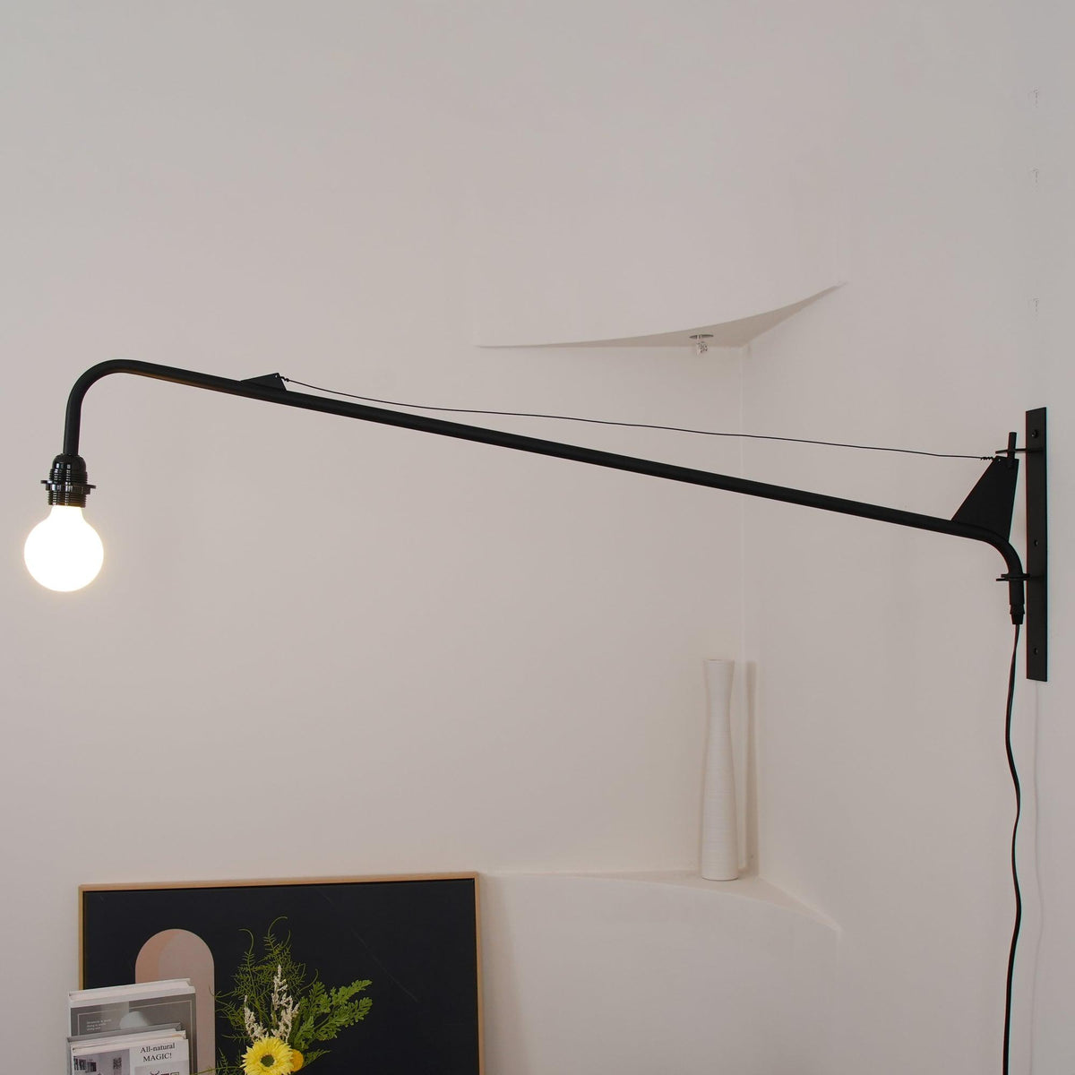 Aplique de pared con brazo largo Vigala sobre un sofá – imagen 14