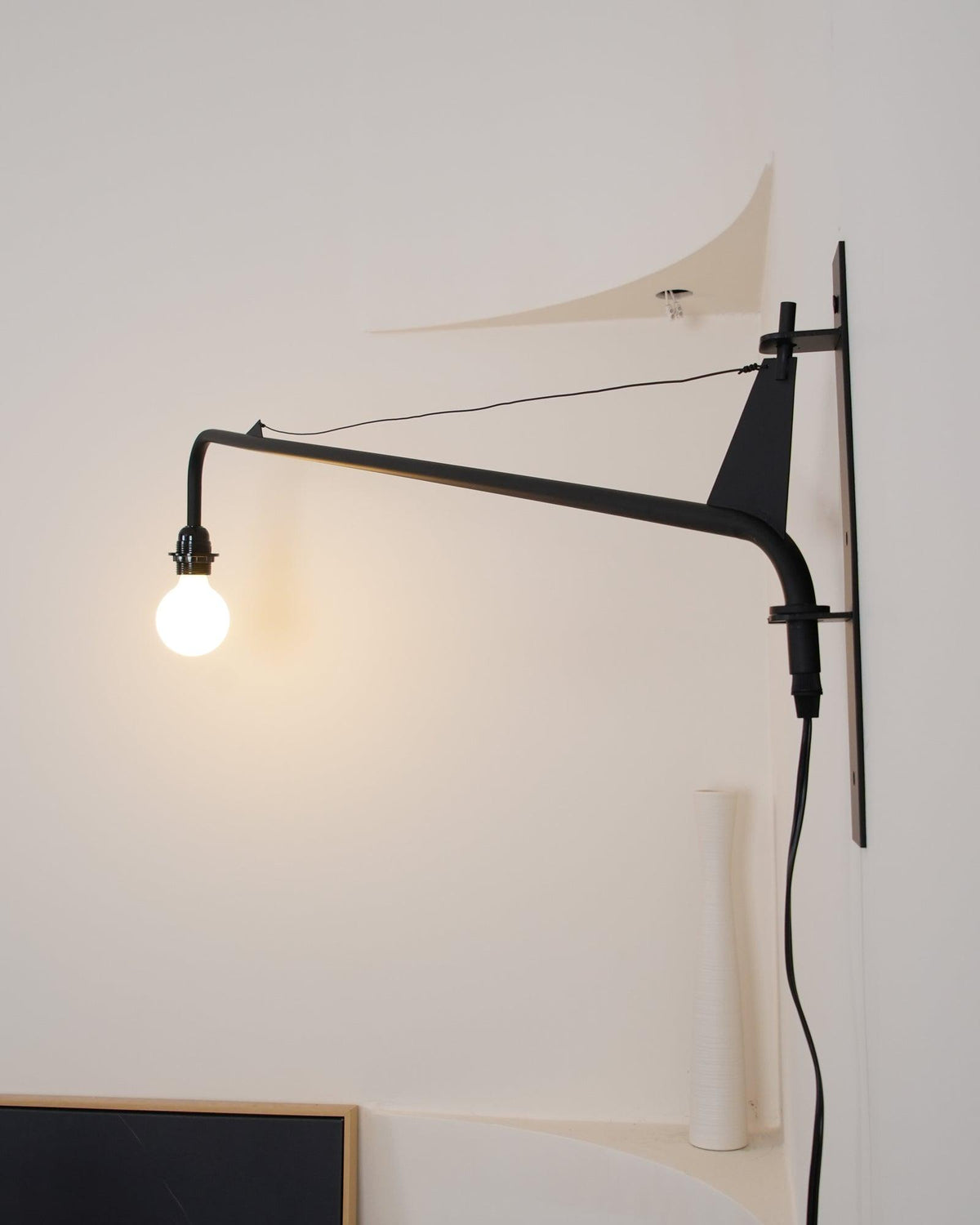 Aplique de pared con brazo largo Vigala sobre un sofá – imagen 17