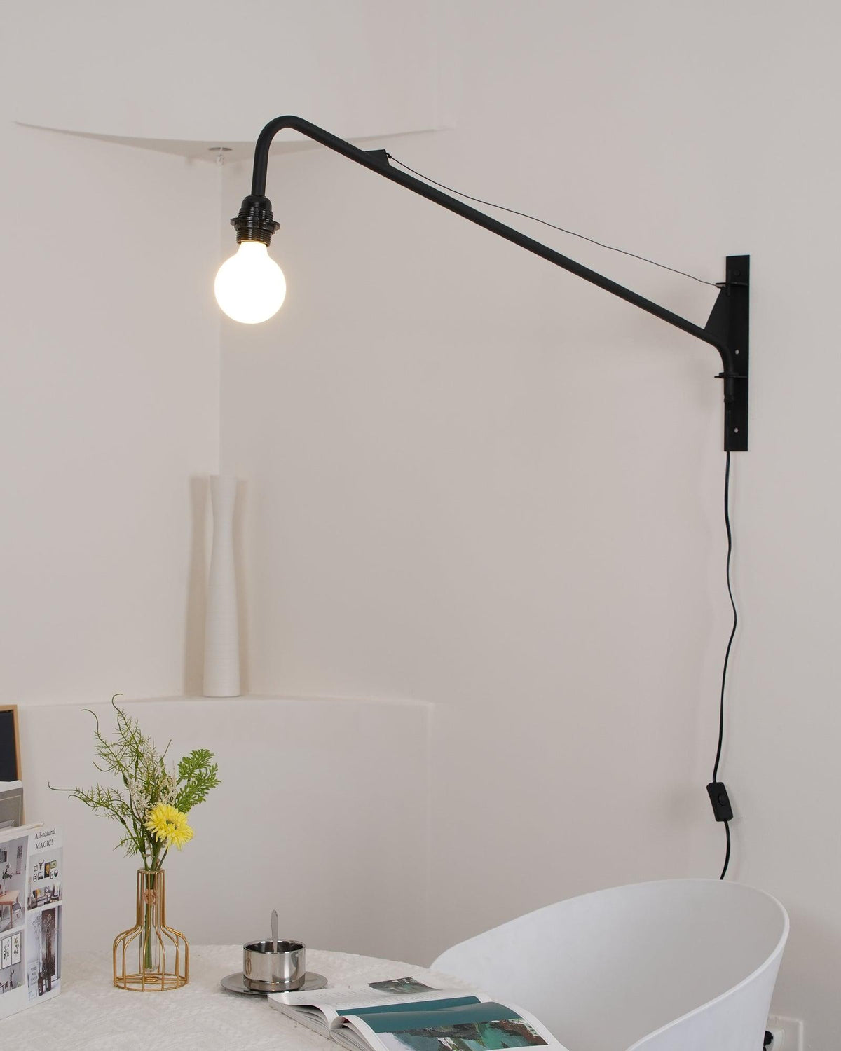 Aplique de pared con brazo largo Vigala sobre un sofá – imagen 18