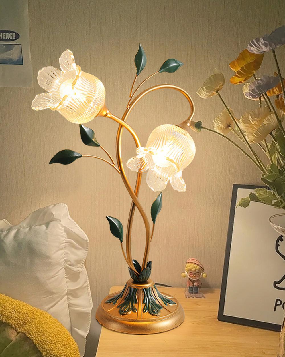 Lámpara de mesa floral Vinela – encendida sobre una mesita