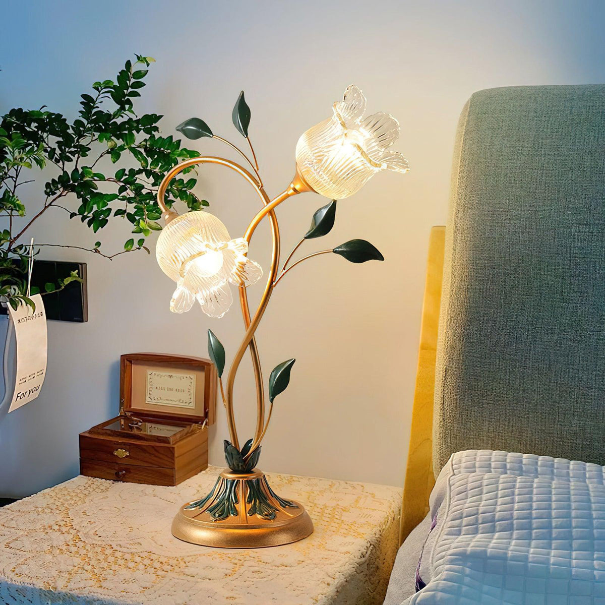 Lámpara de mesa floral Vinela – encendida sobre una mesita