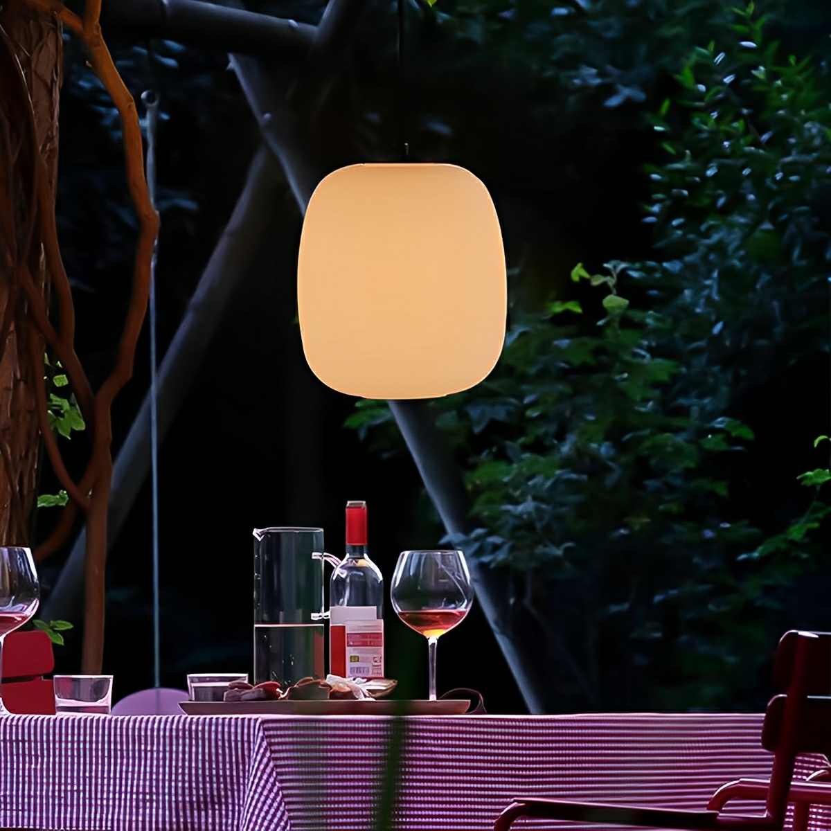 Lámpara colgante de exterior Kioma – colgada de una pérgola sobre la mesa