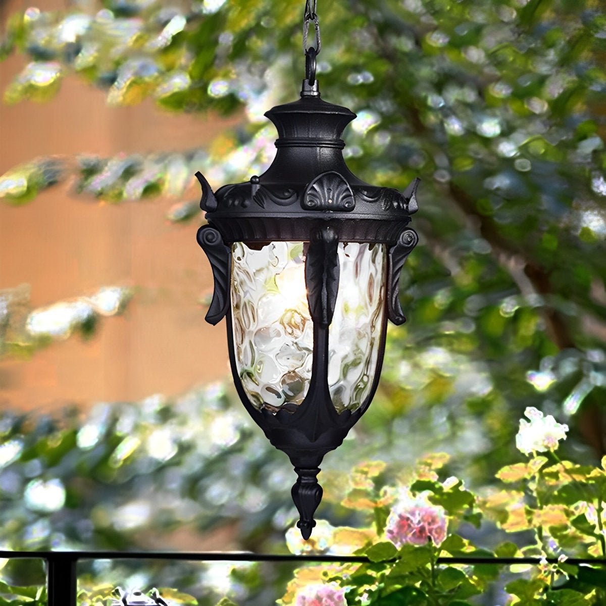 Farol colgante de exterior Ifalo – en negro entre la vegetación