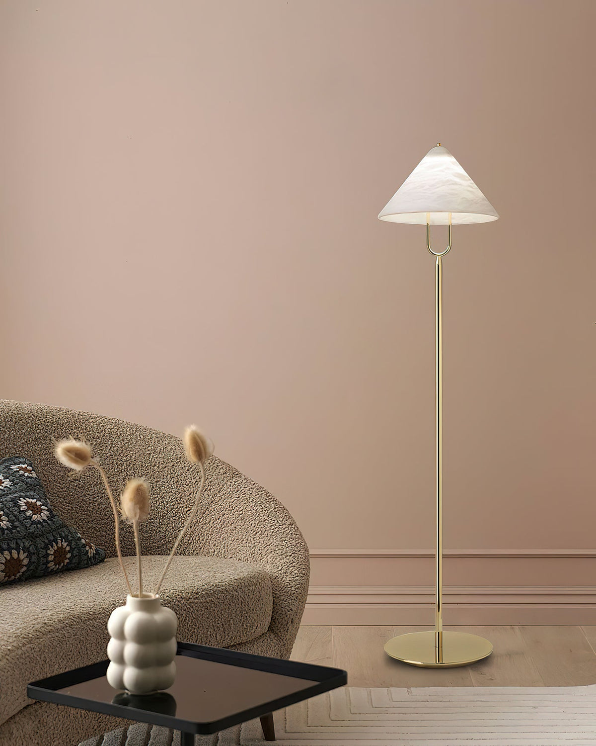 Lámpara de pie Yamira – junto a un sofá bouclé y una pared rosada