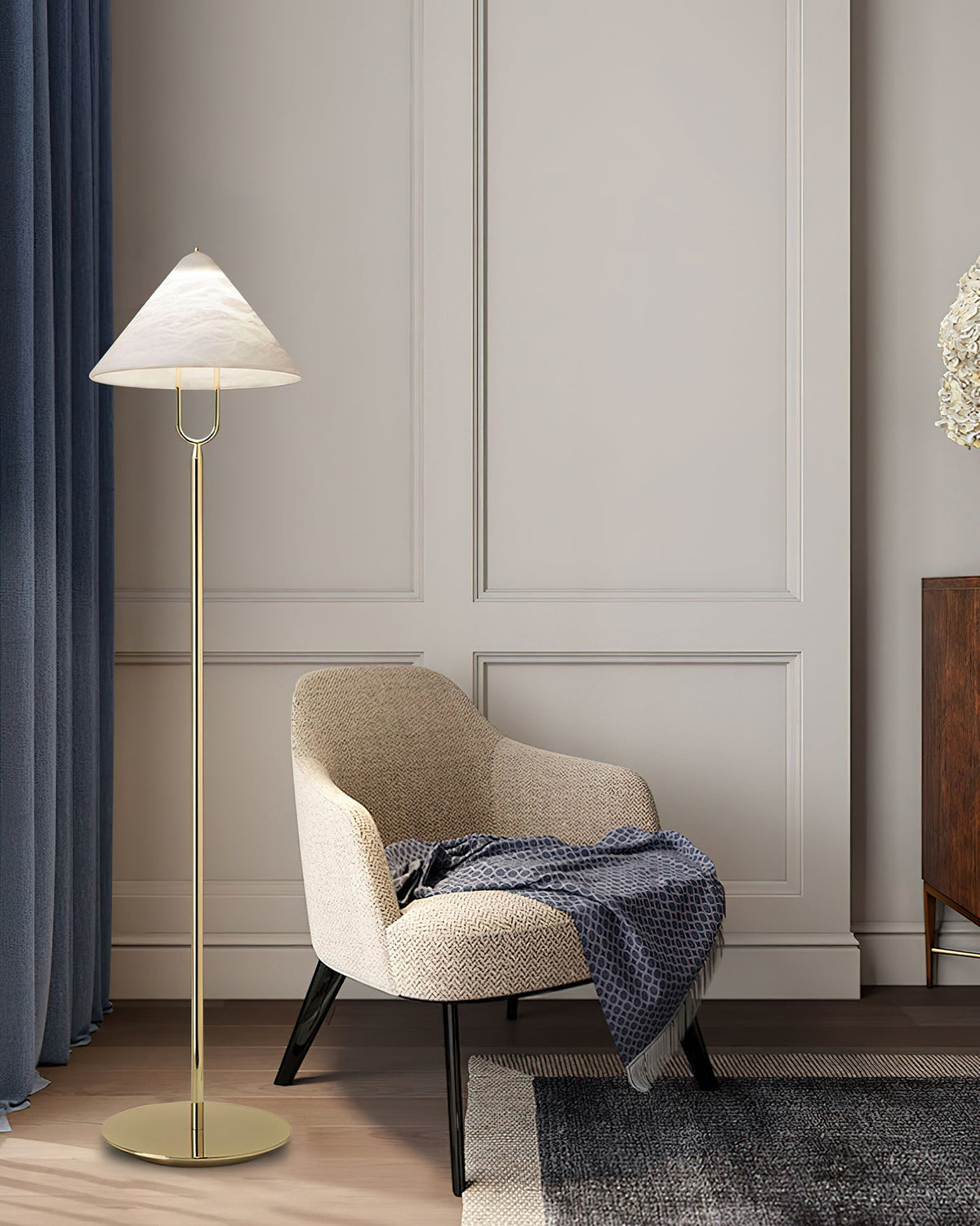 Lámpara de pie Yamira – junto a un sillón y una cortina azul