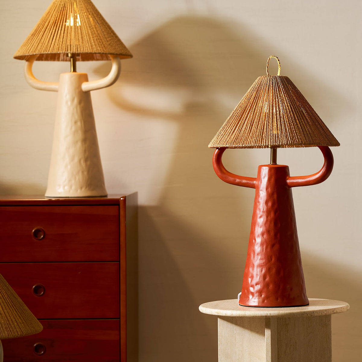 Lámpara de mesa de cerámica Yutela – en beige sobre una cómoda de madera