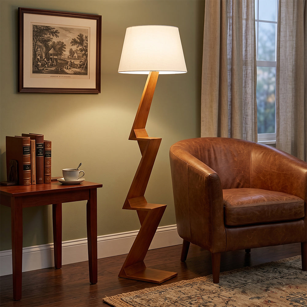 Lámpara de pie de madera en zigzag Zagora – junto a un sillón de piel