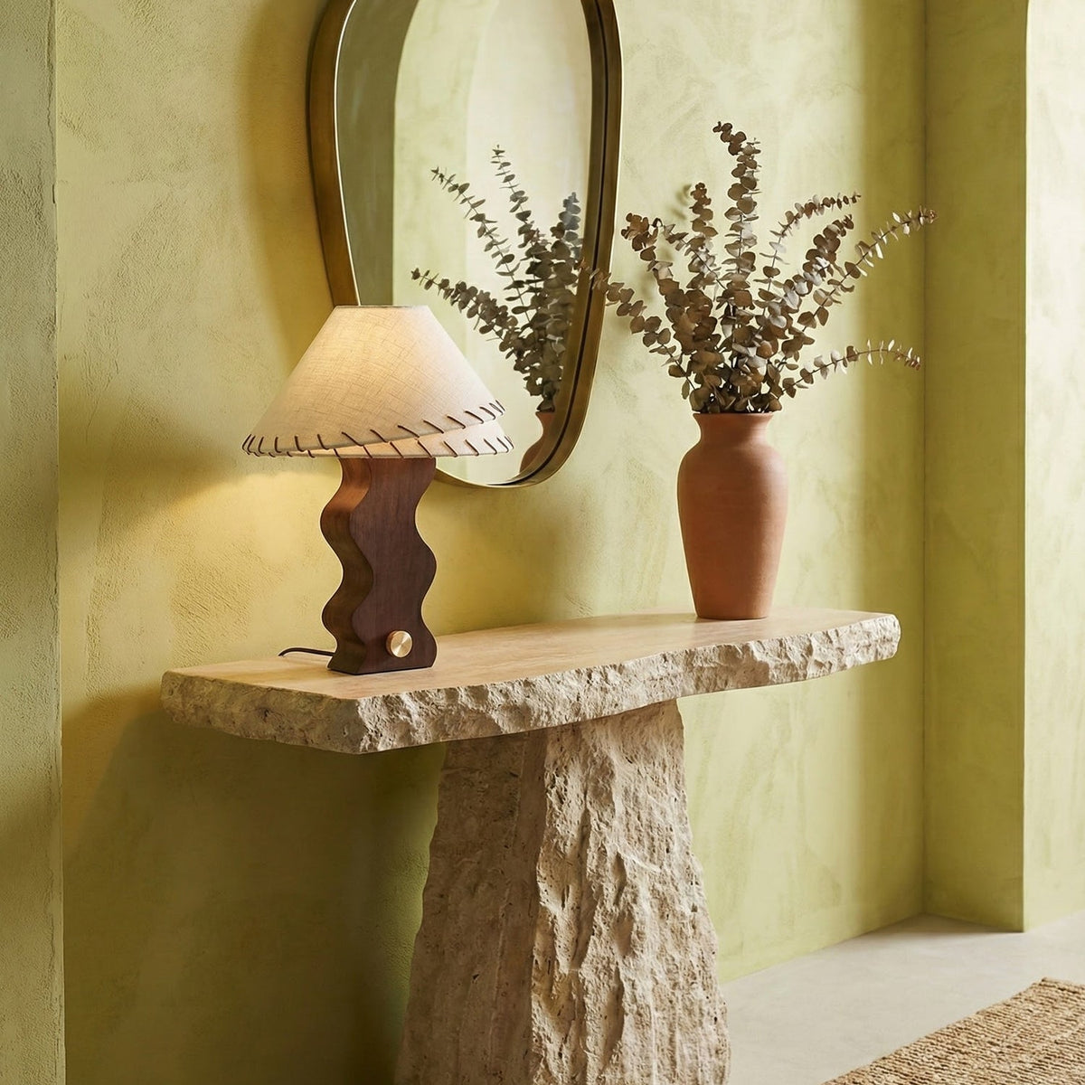 Lámpara de mesa de madera ondulada Zigala – en una consola de piedra